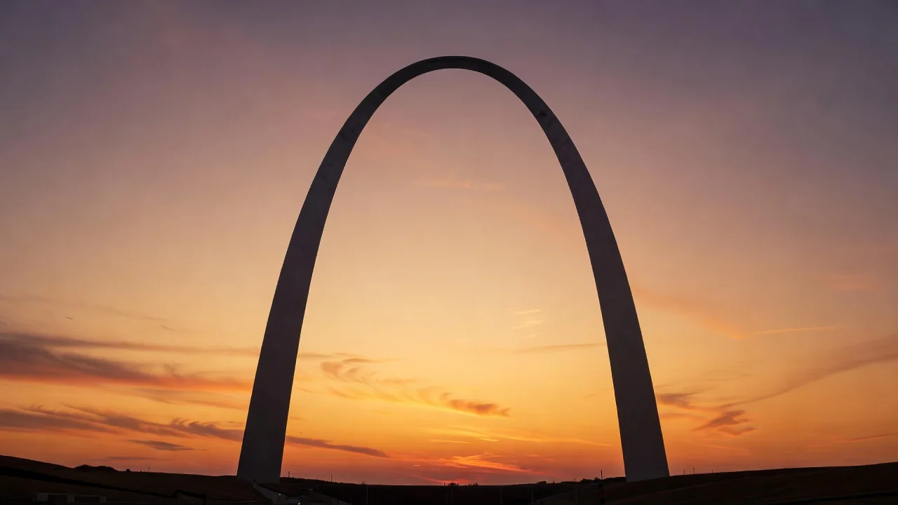 A gateway arch monument silhouette against a warm evening sky